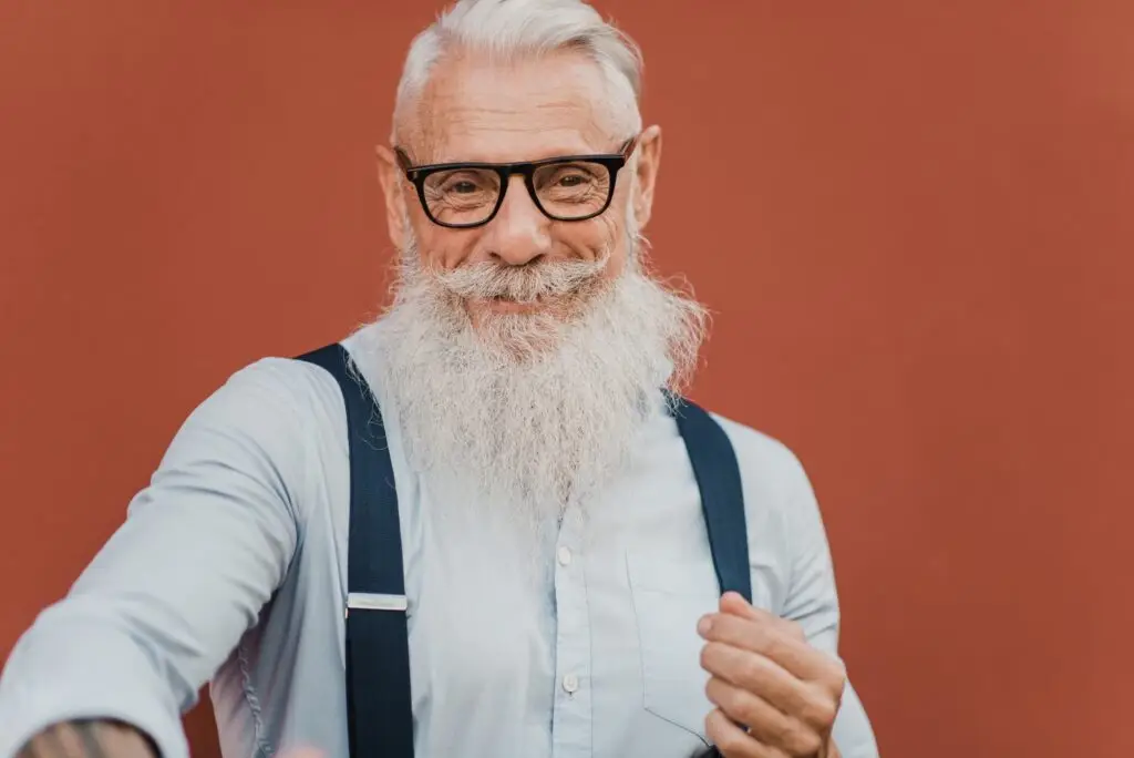 Happy senior man looking at camera wearing modern clothes and glasses